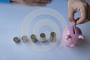 Money saving ideas for future accounting planning. Male hand putting coins in piggy bank Money plans