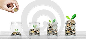 Money savings and business investment concept, bottle of coins on white wood on white background