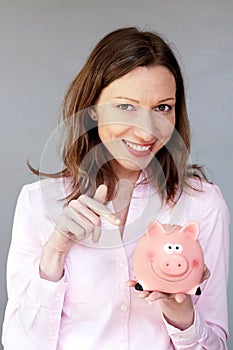 Money savings confident woman holding pink piggy bank moneybox