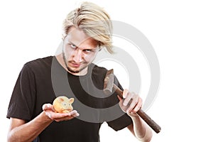 Man about to break piggy bank with hammer