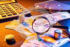 Money is scattered on the table. Banknotes and coins on the table. View of money through a magnifying glass