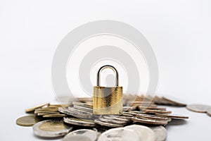 Money and Security Concept. Close up of gold master key lock on pile of coins on white background with copy space for text