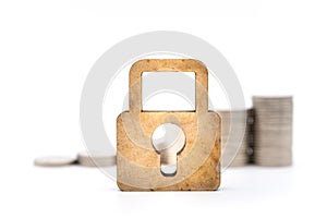 Money and Security Concept. Closeup of  wooden master key lock icon with stack of silver coins on white background