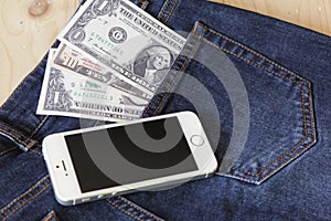 Money and smartphone (gadget) on woodbackground