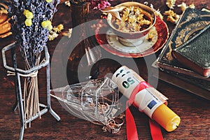 Money spell on wiccan witch altar - a red ribbon tied around a yellow candle with money banknotes