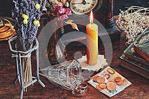 A money spell on a witch altar. Slightly blurred background with a focus on money banknotes, coins next to vintage golden jewelry