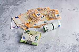 Money in stationery clip and band near pile of paper banknotes five one hundred and fifty euro