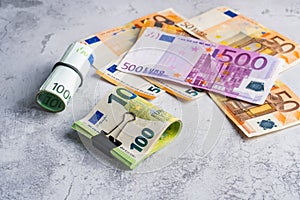Money in stationery clip and band near pile of paper banknotes five one hundred and fifty euro