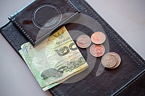 Money tip, notebank and coin on payment black leather tray