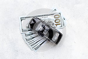 Money to buy or rent a car concept. Toy car with money cash