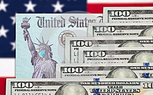 Money and United States IRS Stimulus Check with Statue of Liberty Wearing Face Mask Resting on American Flag