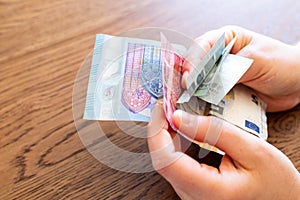 Money and wallet hold in hand. Spending Euro banknotes. Concept image for economy crisis spending review measure to avoid debit