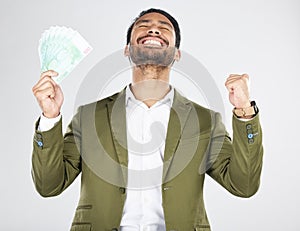 Money, winner and man with fist celebration in studio for payment, loan or cashback on grey background. Cash, award and