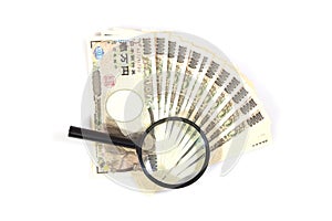 Money yen banknotes under magnifying glass