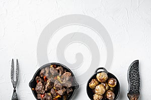 Mongolian beef, pieces of beef stewed in soy sauce, in cast iron frying pan, on white stone  surface, top view flat lay, with copy