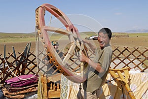 Mongolian man assembles yurt in steppe, circa Harhorin, Mongolia.