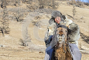 Mongolianman dressed in traditional clothing on a horse