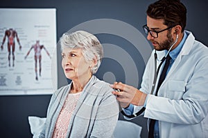 Monitoring her health. a doctor examining a senior patient with a stethoscope in a clinic.