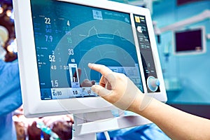 Monitoring patient`s vital sign in operating room. doctor cheking at patient`s vital signs. Cardiogram monitor during