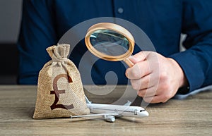 Monitoring the payment of taxes in the aviation industry and british pound sterling money bag.