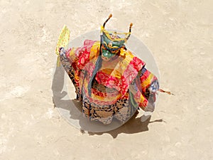 Monk in a bull deity mask with ritual dagger phurpa performs a religious masked and costumed Cham dance of Tibetan Buddhism