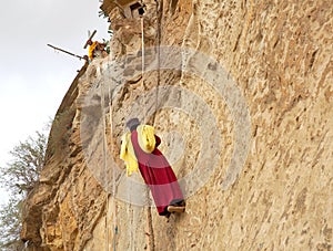 Monk climbing a rock wall at Debre Damo Monastery, Ethiopia