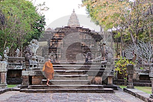 Monk climbing up stairs at Pranom Rung Stone Clastle, Buriram,Thailand photo