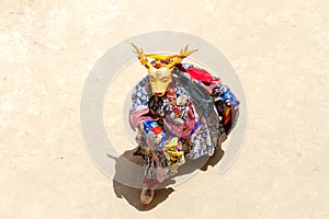 Monk in deer mask performs a religious masked and costumed mystery dance of Tibetan Buddhism during the Cham Dance Festival