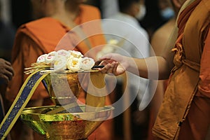 Monk placing cremation flower on the tray.