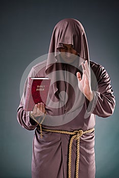 The monk in religious concept on gray background
