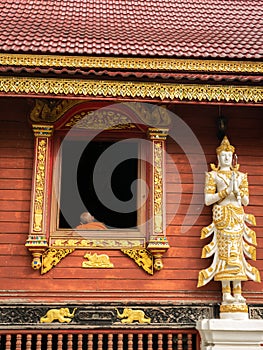 Monk Sat Back in The Window in The Wooden Church