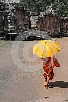 Monk with umbrella walking in the ancient temple