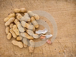 Monkey nuts, groundnuts, peanuts on old wooden board.