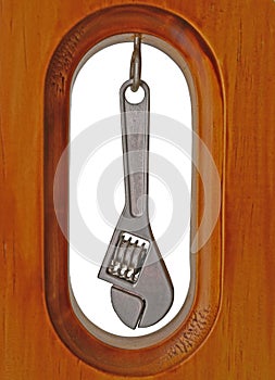 Monkey Wrench hanging inside a wooden border