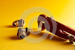 A monkey wrench on the yellow background with some fitting connectors. for design and decoration