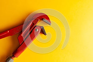 A monkey wrench on the yellow background with some fitting connectors. for design and decoration