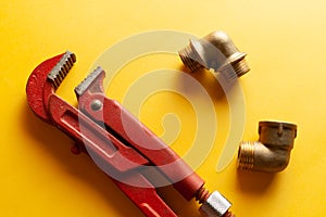 A monkey wrench on the yellow background with some fitting connectors. for design and decoration