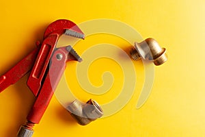 A monkey wrench on the yellow background with some fitting connectors. for design and decoration
