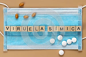 Viruela sÃÂ­mica is the name of the monkeypox virus in Spanish. The word is laid out with wooden cubes on a surgical face mask. photo