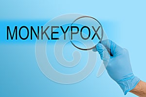 Monkeypox virus symbol. Concept words Monkeypox virus on white note. Doctor hand in blue glove with metallic pen photo