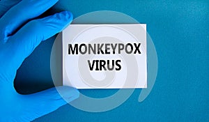 Monkeypox virus symbol. Concept words Monkeypox virus on white card. Doctor hand in blue glove with white card. Medical and photo