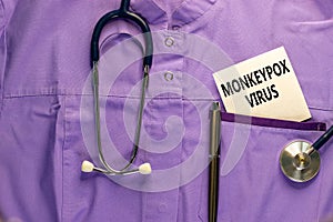 Monkeypox virus symbol. Medical uniform, white card with concept words Monkeypox virus, metalic pen and stethoscope. Medical and photo