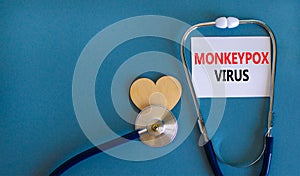 Monkeypox virus symbol. White card with concept words Monkeypox virus, wooden heart and stethoscope. Medical and Monkeypox virus photo