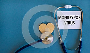 Monkeypox virus symbol. White card with concept words Monkeypox virus, wooden heart and stethoscope. Medical and Monkeypox virus photo