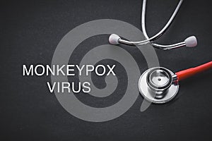 MONKEYPOX VIRUS words written with stethoscope on black background. photo
