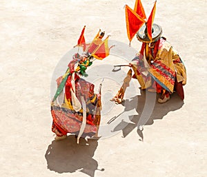 monks perform a symbolic battle during the religious masked and costumed mystery dance of Tibetan Buddhism during the Cham Dance