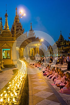 Monks praying in front of candles