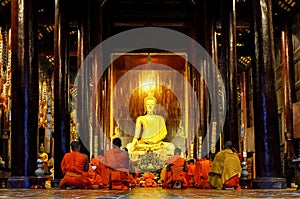 Monks praying in Wat Phan Tao