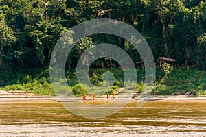 Monks on the river bank in Luang Prabang, Laos. Copy space for text.