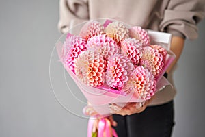 Mono bouquet of pink dahlias. Beautiful bouquet of flowers in womans hands. the work of the florist at a flower shop